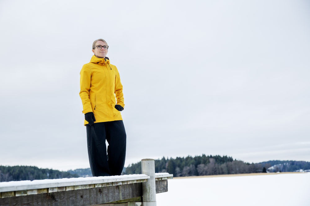 På bilden syns en kvinna i medelåldern vid namn Linda Mannila. Hon står utomhus på en brygga vid ett istäckt hav. I bakgrunden ser man en ö med granar. Hon är klädd i en knallgul vadlång jacka och har lösa mörka byxor på sig. Hon är barhuvad, han blont hår tillbakadraget i en svans och har mörja glasögon. Hon ser inte in i kameran utan tittar till höger . Hon ser allvarlig ut.