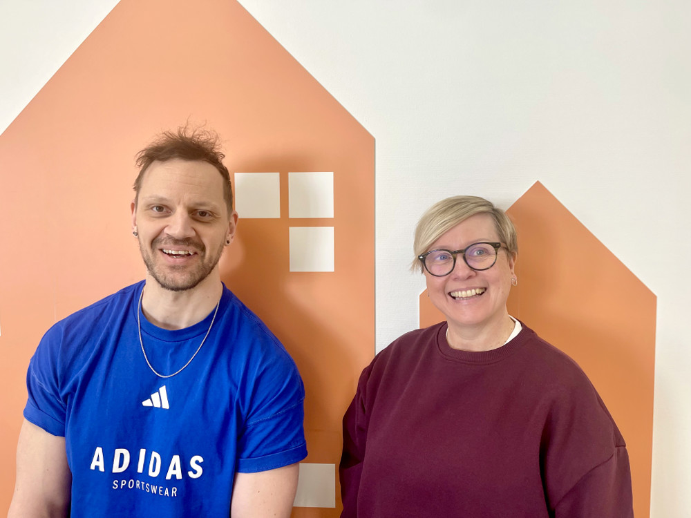 På bilden syns två personer, Daniel Enbacka och Misa Möller som jobbar på skolan Valteri med barn med funktionsnedsättningar.  De är fotade framför en vit vägg där man målat ett stiliserat hus i ljusorange. Man ser dem till ungefär midjehöjd. Båda tittar in i kameran och skrattar. Till vänster finns  mannen med brunt hår och bruna ögon. Han är kläss i en knallblå t-shirt där det står Adidas i vita bokstäver. Kvinnan har kort ljust hår. stora glasögon med mörka bågar och hon är klädd i en vinröd tröja med en vit t-shirt under.