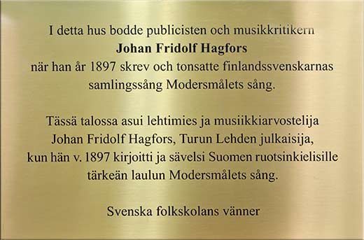 Plaketten till minnet av Hagfors: I detta hus bodde publicisten och musikkritikern Johan Fridolf Hagfors närhan år 1897 skrev och tonsatte finlandssvenskarnas samlingssång Modersmålets sång.